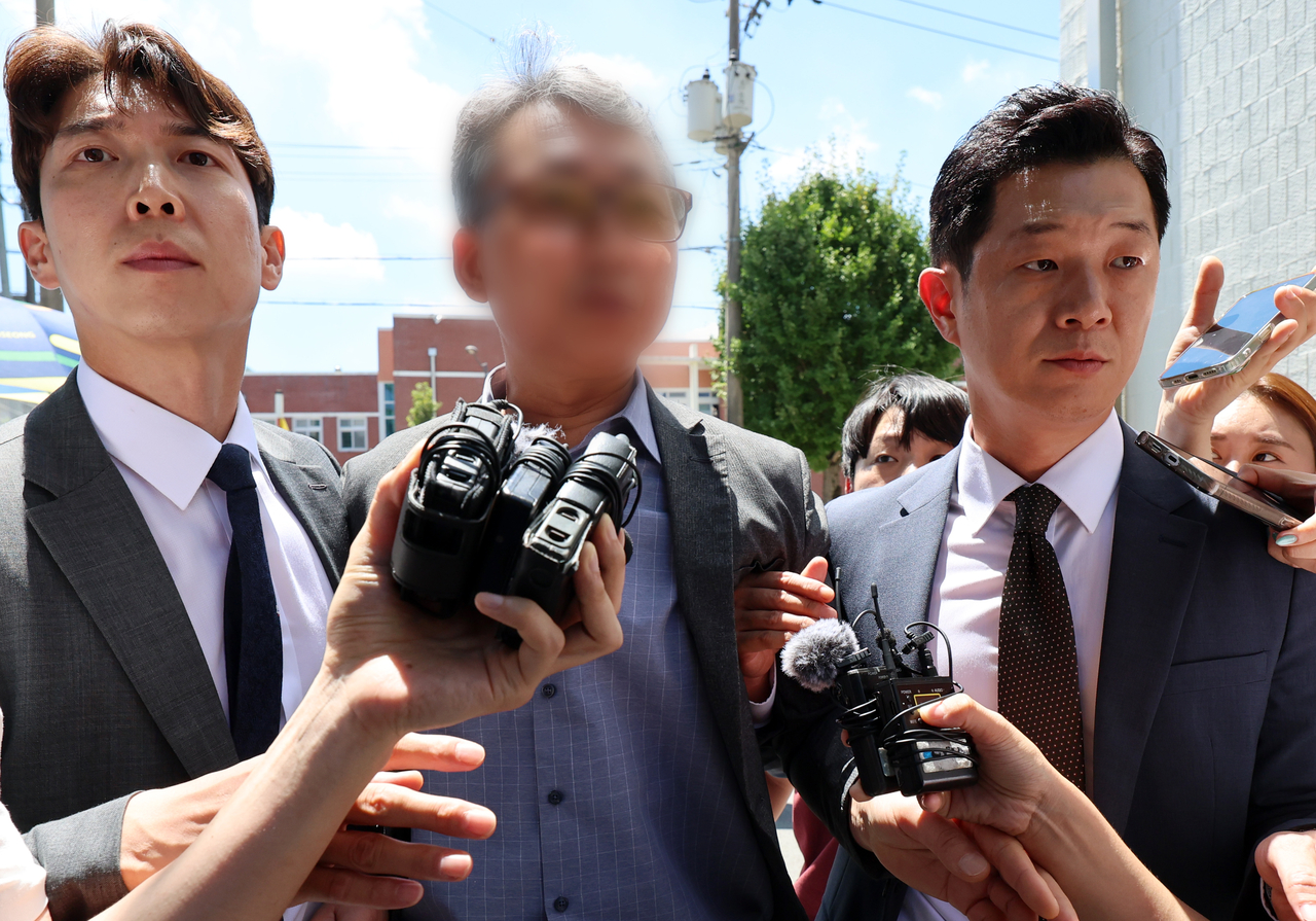 The former chief of the criminal investigation division at Gwangsan Police Station (center), who is accused of interfering in investigations related to Jang Yoon-gi's rape and murder charge, leaves the Gwangju District Court on July 31 after attending a prearrest hearing. (Yonhap)