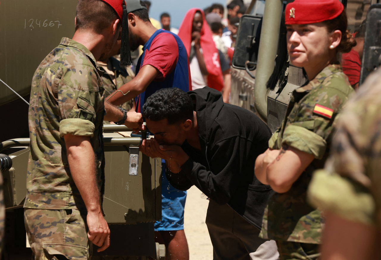 A migrant who crossed into Ceuta from Morocco drinks water provided by the Spanish military in Ceuta, Spain, Sunday. (Reuters-Yonhap)