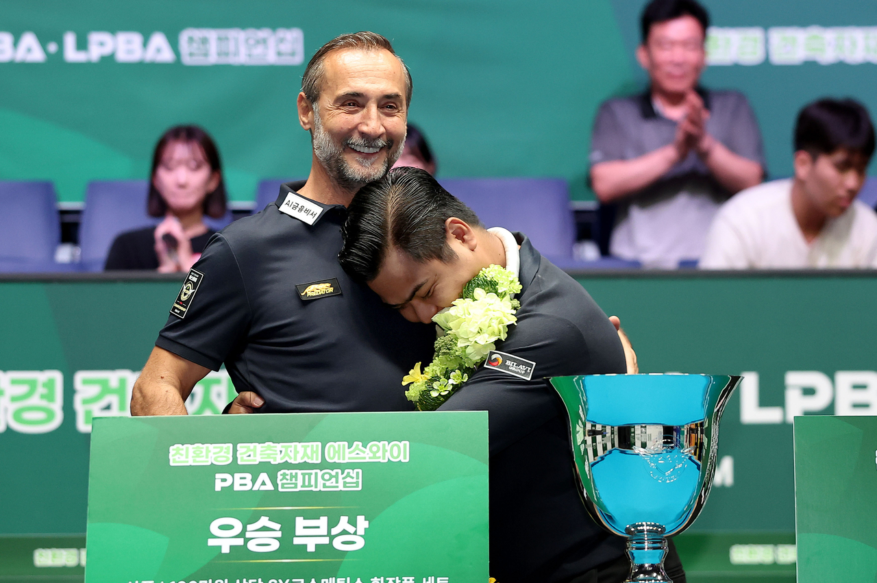 Champion T. Nguyen (right) embraces runner-up Semih Sayginer after the final.