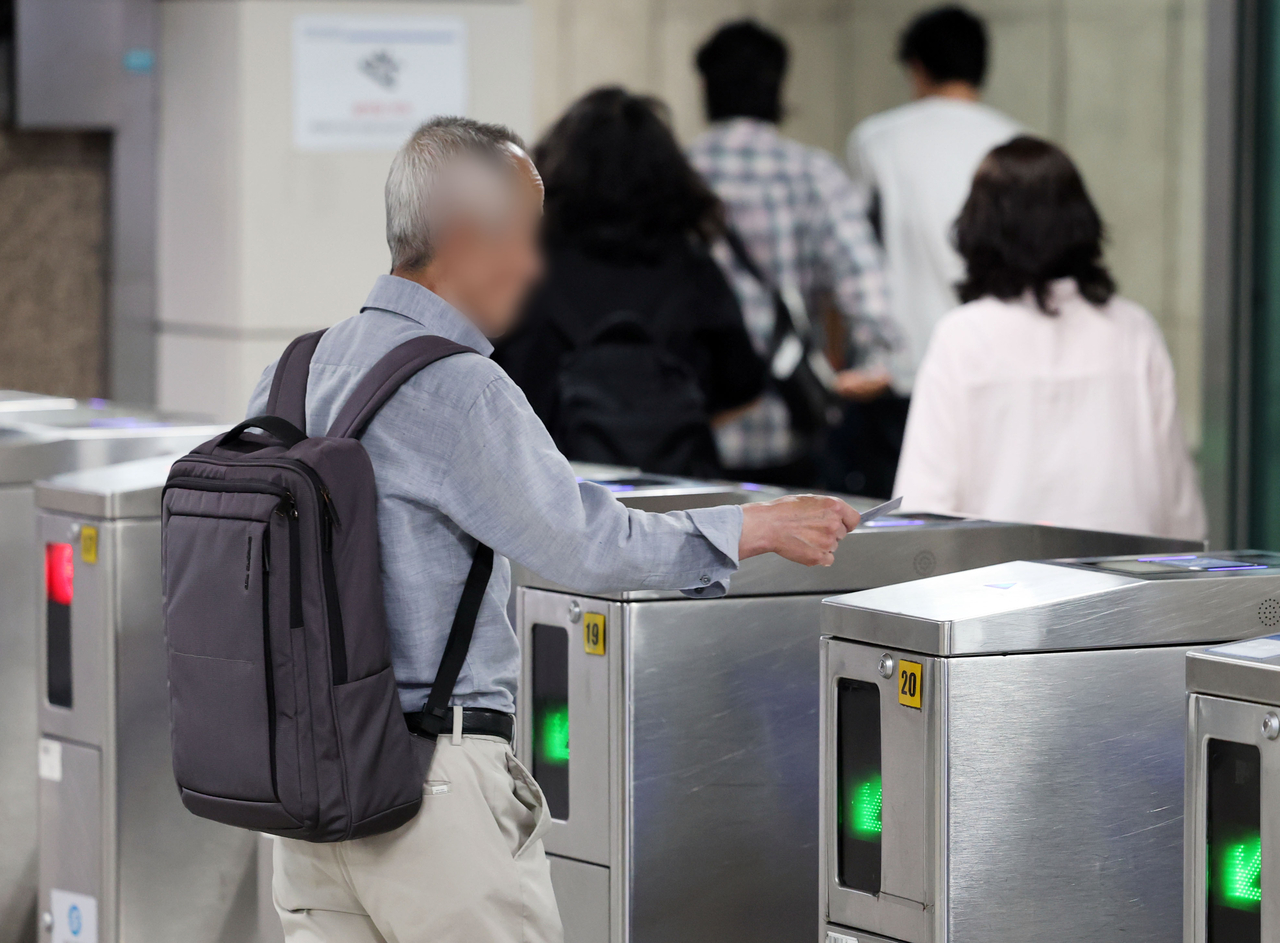 A senior citizen passes through the fare gate at Jonggak Station on Seoul Subway Line No. 1 on July 22. (Yonhap)