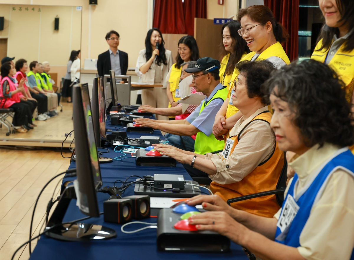 Older adults play cognitive games using interactive touch pads at a welfare center in Daejeon's Yuseong-gu on July 29. (Yonhap)