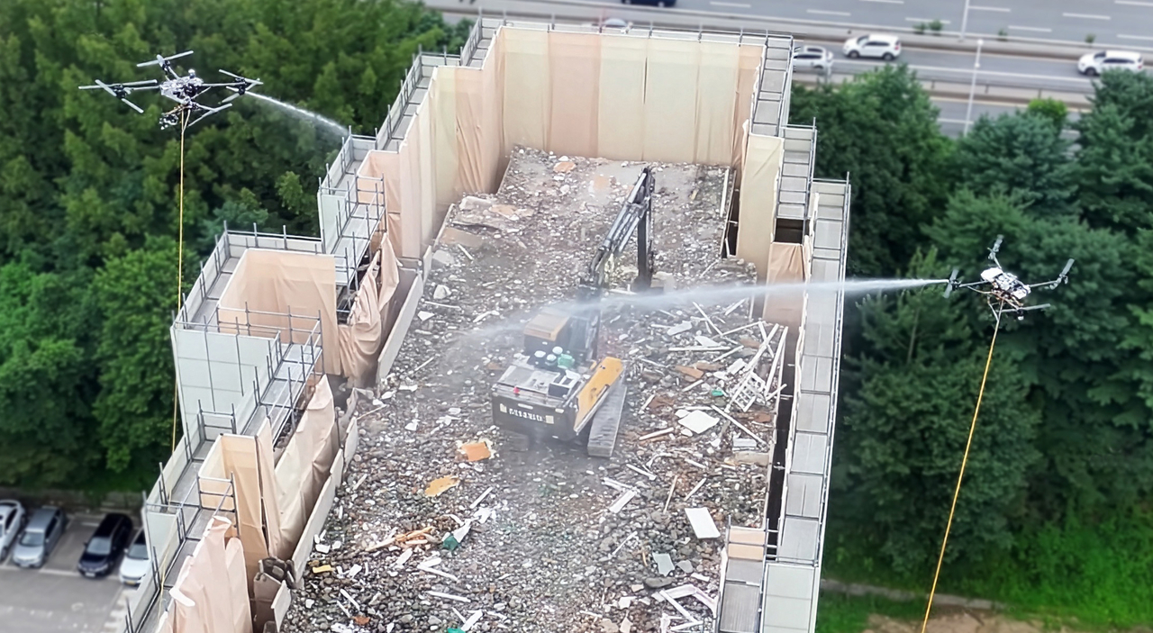 Hyundai E&C conducts a dust-suppression demonstration using a water-spraying drone at the Gwacheon Jugong complexes 8 and 9 reconstruction project site. [Hyundai E&C]