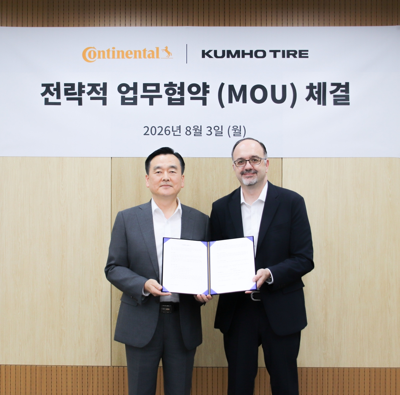 김성(왼쪽) 금호타이어 한국영업부문 상무와 니코 키리아조폴로스 콘티넨탈타이어 코리아 교체타이어 부문 대표가 업무협약을 체결하고 기념 사진 촬영을 하고 있다. [금호타이어 제공]