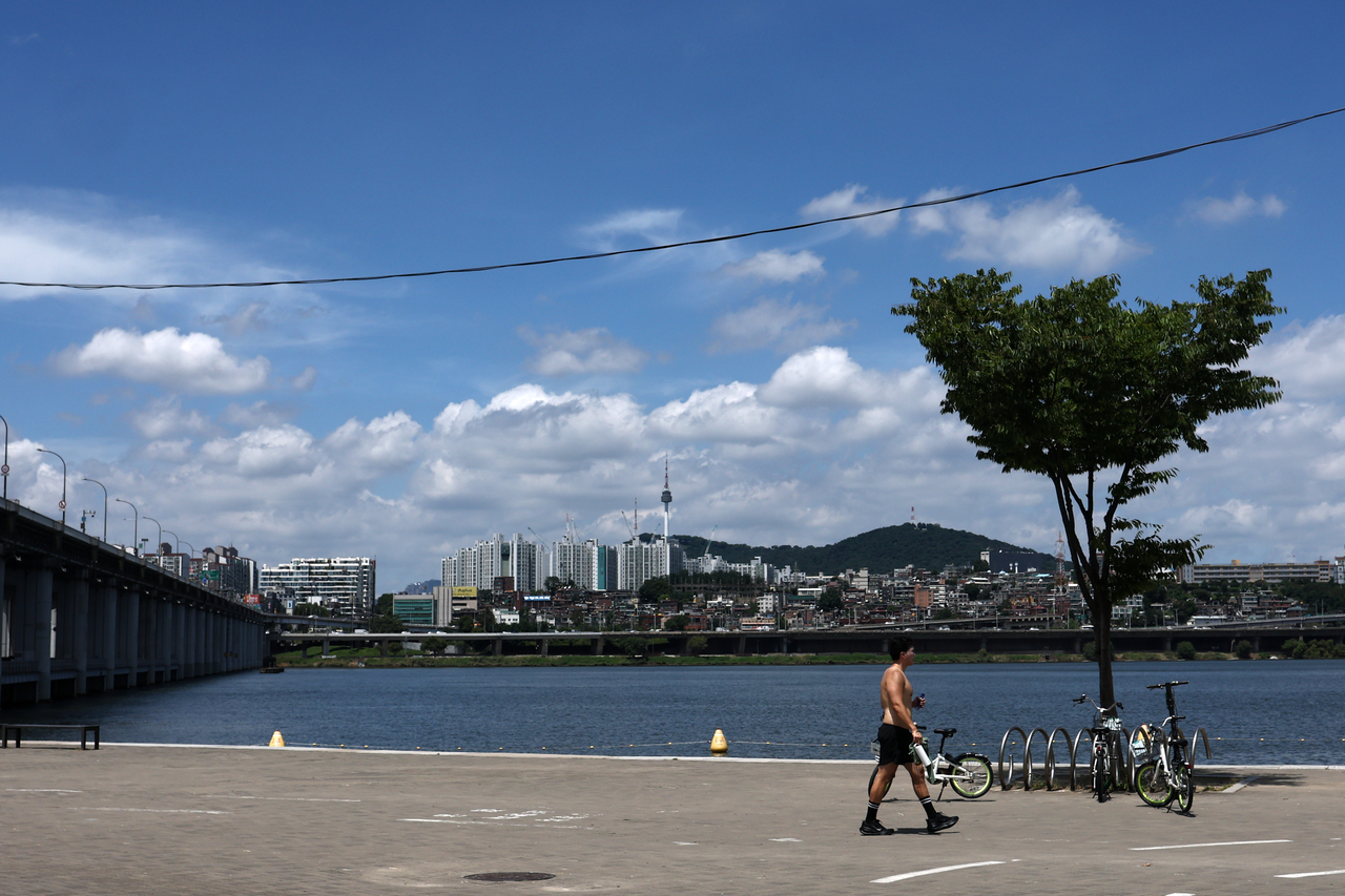 A shirtless man walks along the Han River in Seoul on July 29. (Yonhap)