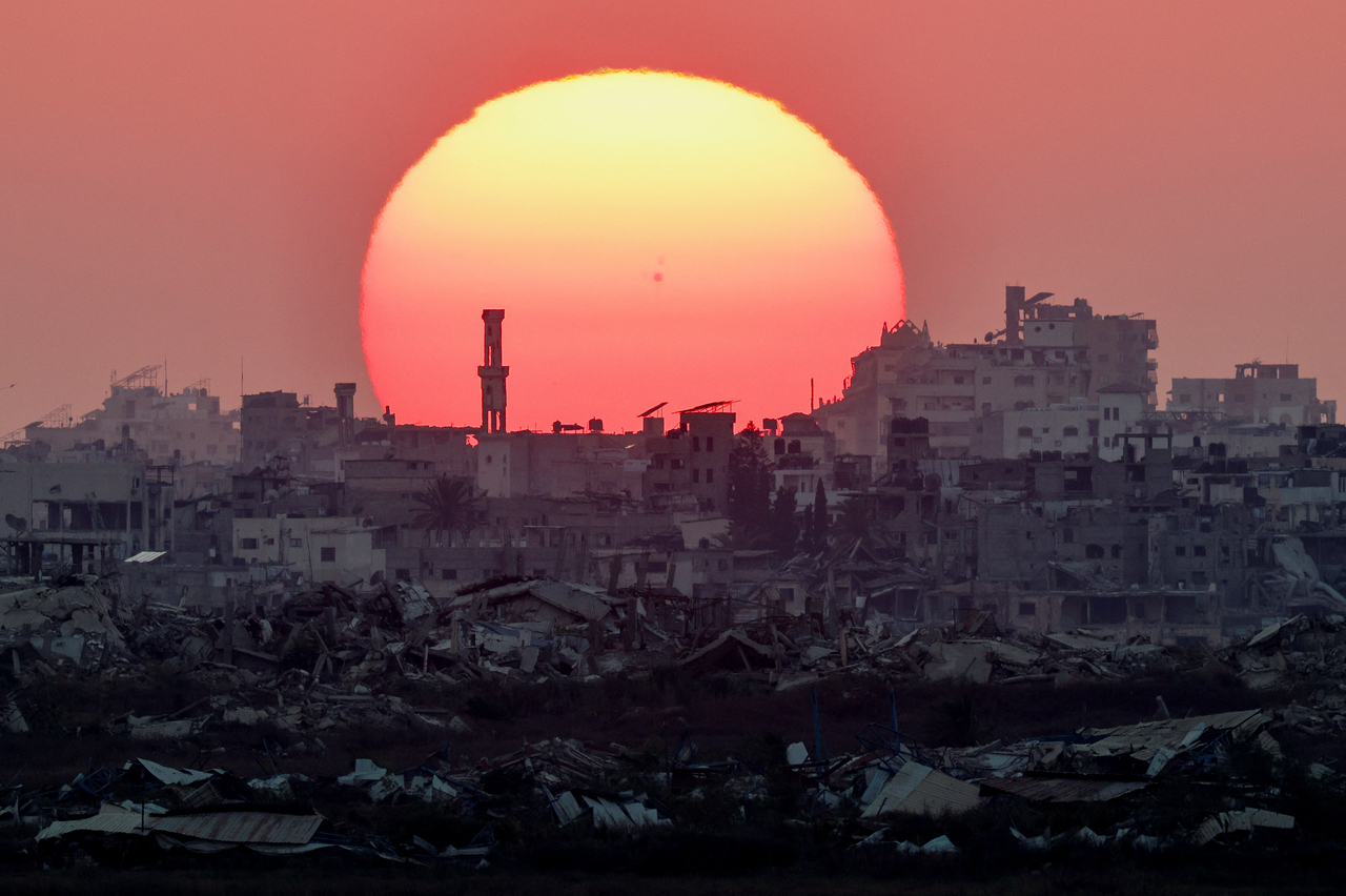 The sun sets over Gaza, as seen from the Israeli side of the border, Sunday. (Reuters-Yonhap)