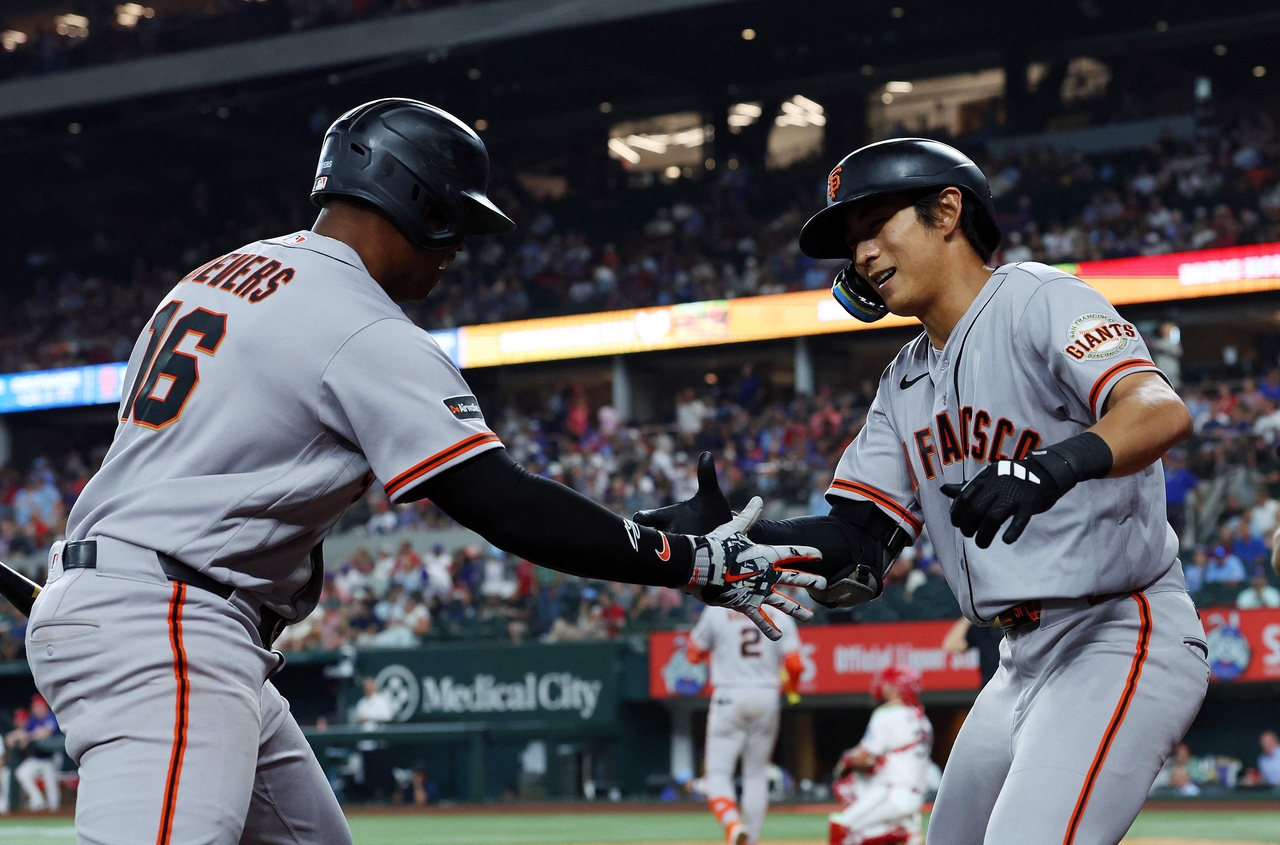 Rafael Devers (left) of the San Francisco Giants congratulates teammate Lee Jung-hoo's solo home run against the Texas Rangers, at Globe Life Field in Arlington, Texas, Monday.     (AFP-Yonhap)
