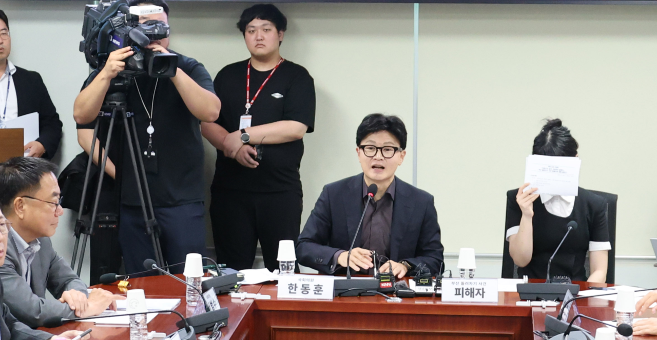 People Power Party Rep. Suh Bum-soo (left) and crime victim Kim Jin-joo (right) listen to independent Rep. Han Dong-hoon (seated, center) during a debate session at the National Assembly on Tuesday.(Yonhap)