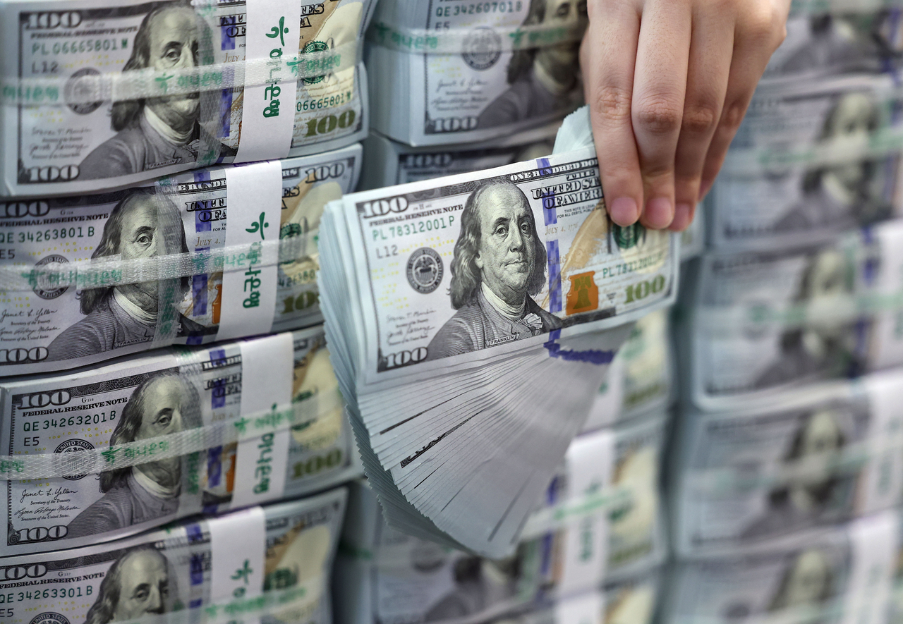 In this file photo taken July 3, an official piles up US dollar bank notes at Hana Bank's Counterfeit Notes Response Center in Seoul. (Yonhap)