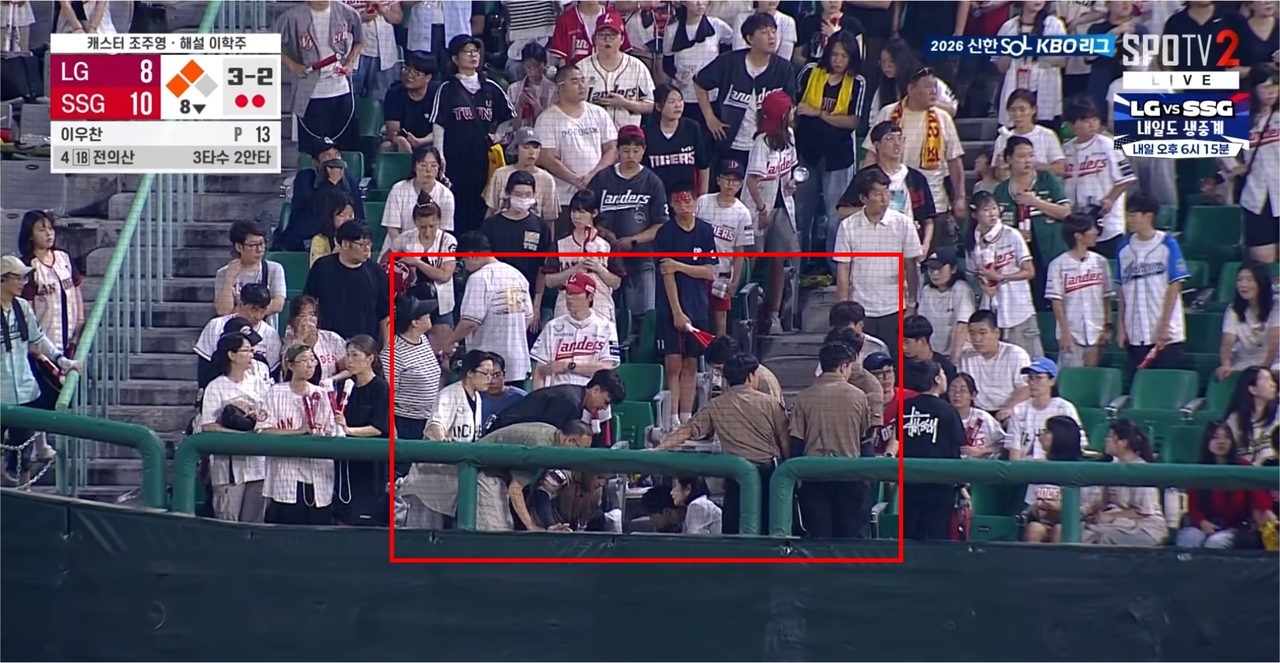 A baseball fan collapses during the bottom of the eighth inning of a game between the LG Twins and SSG Landers, in Incheon on Tuesday. (Screenshot captured from YouTube)