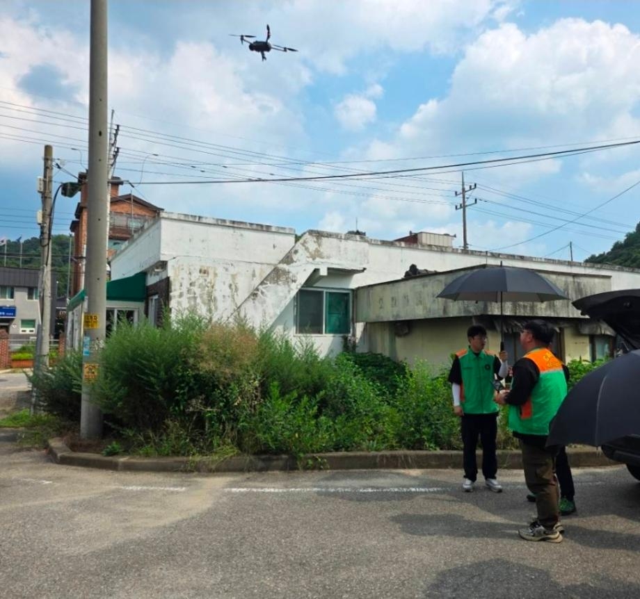 A drone patrols a heat-vulnerable farming area in Sejong as disaster response workers conduct an on-site inspection. (Sejong City)