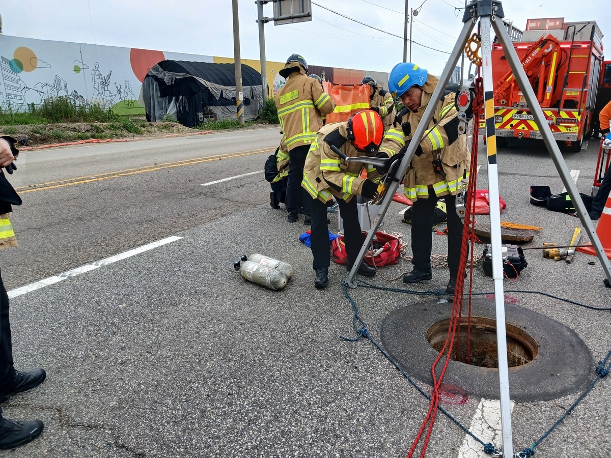 Firefighters search for a missing person in a manhole on a road in Byeongbang-dong, Gyeyang-gu, Incheon, on July 6 last year. [Incheon Fire Headquarters]