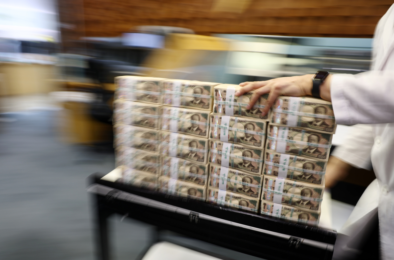A staff member at Hana Bank's counterfeit-response center in Seoul displays yen banknotes. [Yonhap]