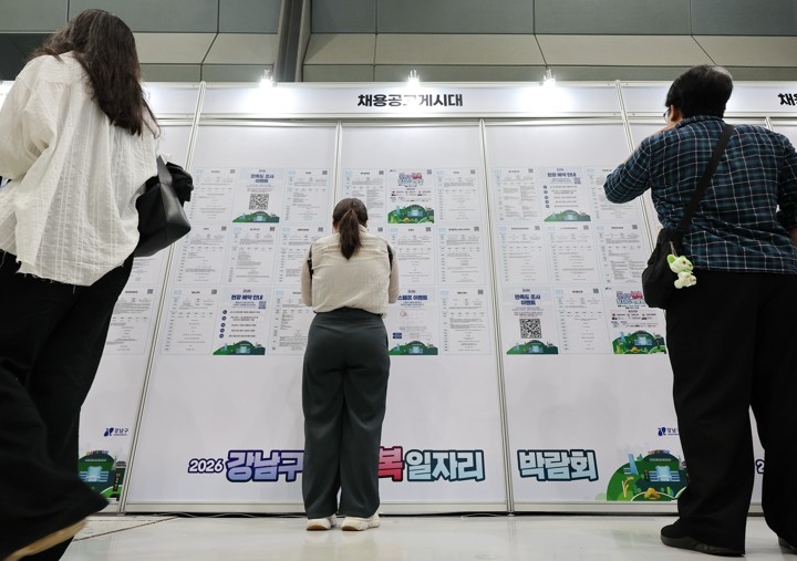 Job seekers look through recruitment notices at a job fair at Coex in Gangnam-gu, southern Seoul, on July 15. (Yonhap)