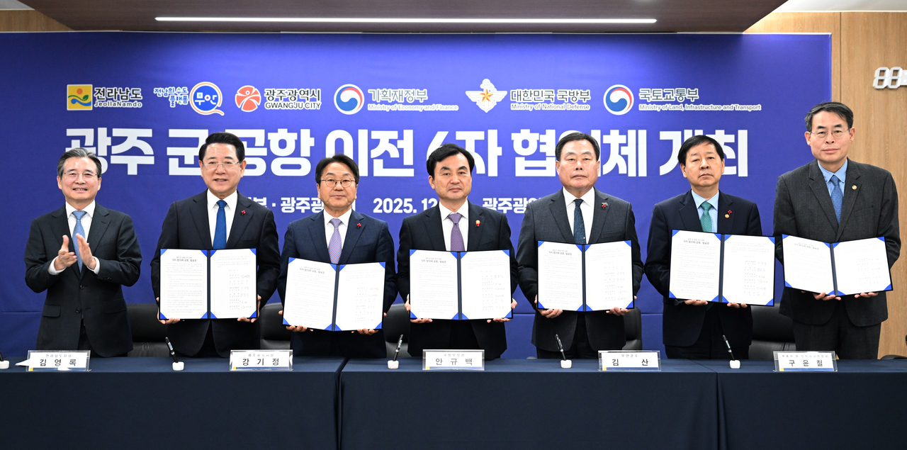 Attendees sign a joint declaration at the first meeting of the six-party consultative body on the relocation of Gwangju's military airport, held at Gwangju Urban Corporation in Seo-gu, Gwangju, on Dec. 17, 2025. The meeting produced an agreement to consolidate and relocate Gwangju's military and civilian airports to Muan. From left: Kim Yong-beom, presidential office policy chief; Kim Yeong-rok, South Jeolla Province governor; Kang Gi-jeong, Gwangju mayor; Defense Minister Ahn Gyu-back; Kim San, Muan-gun chief; Deputy Prime Minister Koo Yun-cheol, who also serves as minister of economy and finance; and Kang Hui-eop, second vice minister of land, infrastructure and transport. [Gwangju-Jeonnam Press Photographers Association/Yonhap]