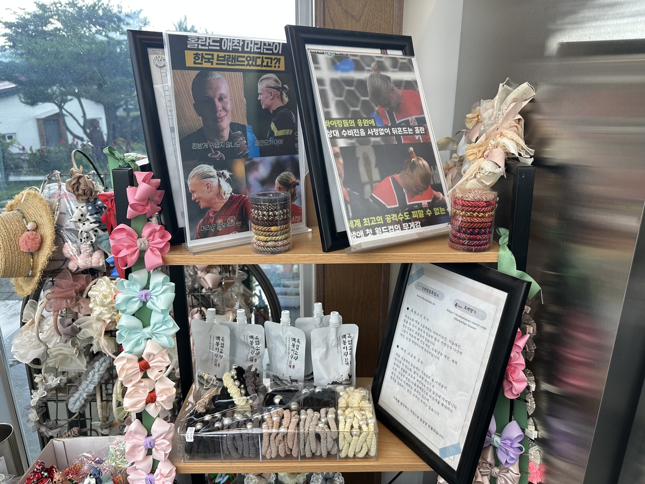 Cafe Basecamp in Chuncheon, run by Cho Hyun-tae, displays Dooji hair ties alongside printouts of Erling Haaland wearing Kknekki. (Tammy Park/The Korea Herald)