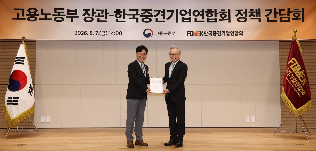 Choi Jin-sik, chairman of the Korea Federation of Mid-sized Companies, hands a set of employment and labor regulation reform proposals to Minister of Employment and Labor Kim Young-hoon. Choi said working hours and minimum wage should be left to voluntary negotiation between companies and workers. [Korea Federation of Mid-sized Companies]