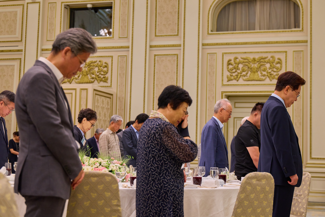 President Lee Jae Myung observes a moment of silence with attendees during a luncheon at Cheong Wa Dae in Seoul on Friday, held to comfort victims of state violence and mark the launch of the third Truth and Reconciliation Commission. (Cheong Wa Dae via Yonhap)