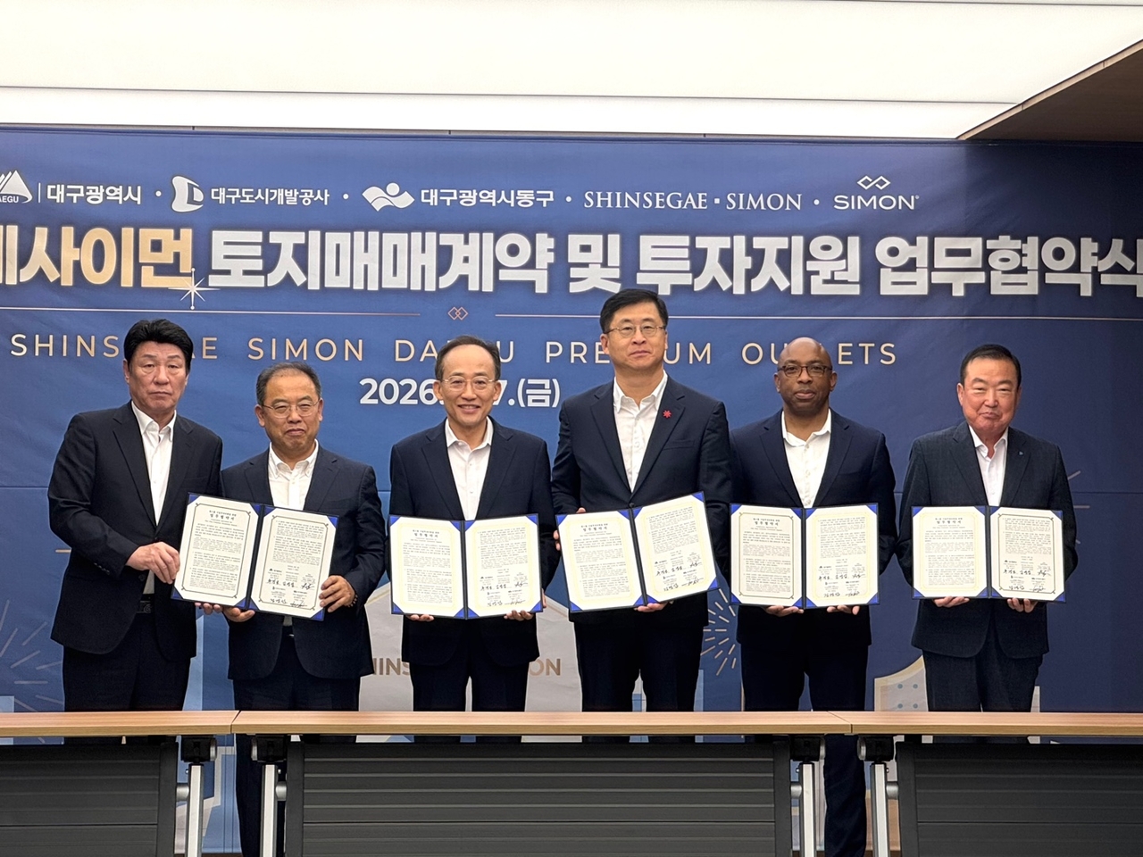 신세계사이먼이 7일 오전 대구시청 산격청사에서 ‘대구 프리미엄 아울렛’ 개발을 위한 토지매매 계약을 체결했다. (왼쪽부터) 강대식 국회의원, 우성진 동구청장, 추경호 대구광역시장, 김영섭 신세계사이먼 대표이사, 우체 아큐주오 사이먼 개발재무담당 부사장, 정명섭 대구도시개발공사 사장이 기념사진을 촬영하고 있다. [신세계사이먼 제공]