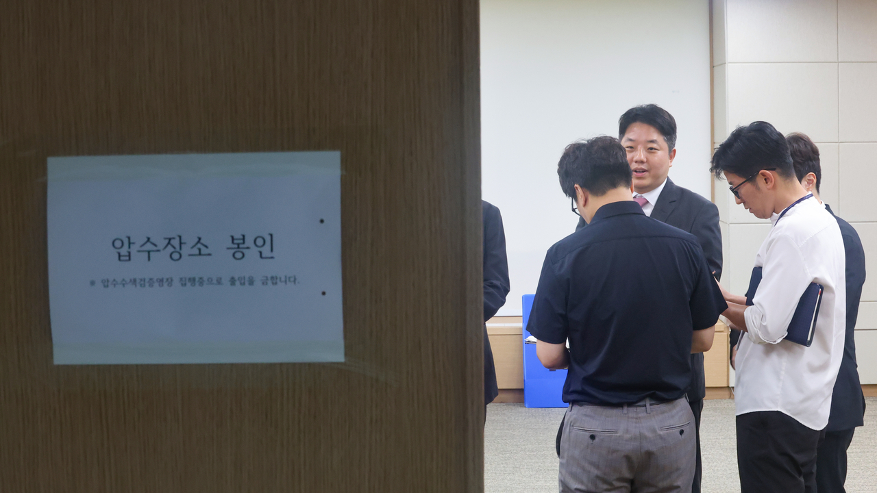 This file photo, taken July 23, shows investigators of a joint prosecution-police team preparing to carry out a search and seizure at the National Election Commission's office in Gwacheon, just south of Seoul, as part of a widening probe into ballot shortages during the June 3 local elections. (Yonhap)
