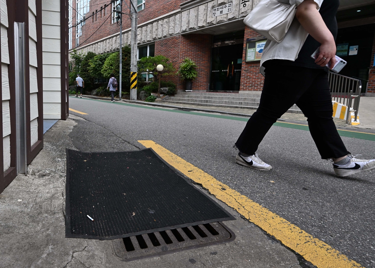 A mat covers a storm drain in Dongjak-gu, southern Seoul. Covers are often left on drains to block sewer odors or prevent illegal dumping. (Lee Sang-sub / The Korea Herald)