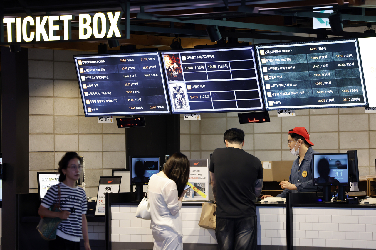 A moviegoer purchases a ticket at a movie theater in Seoul on July 7. (Newsis)