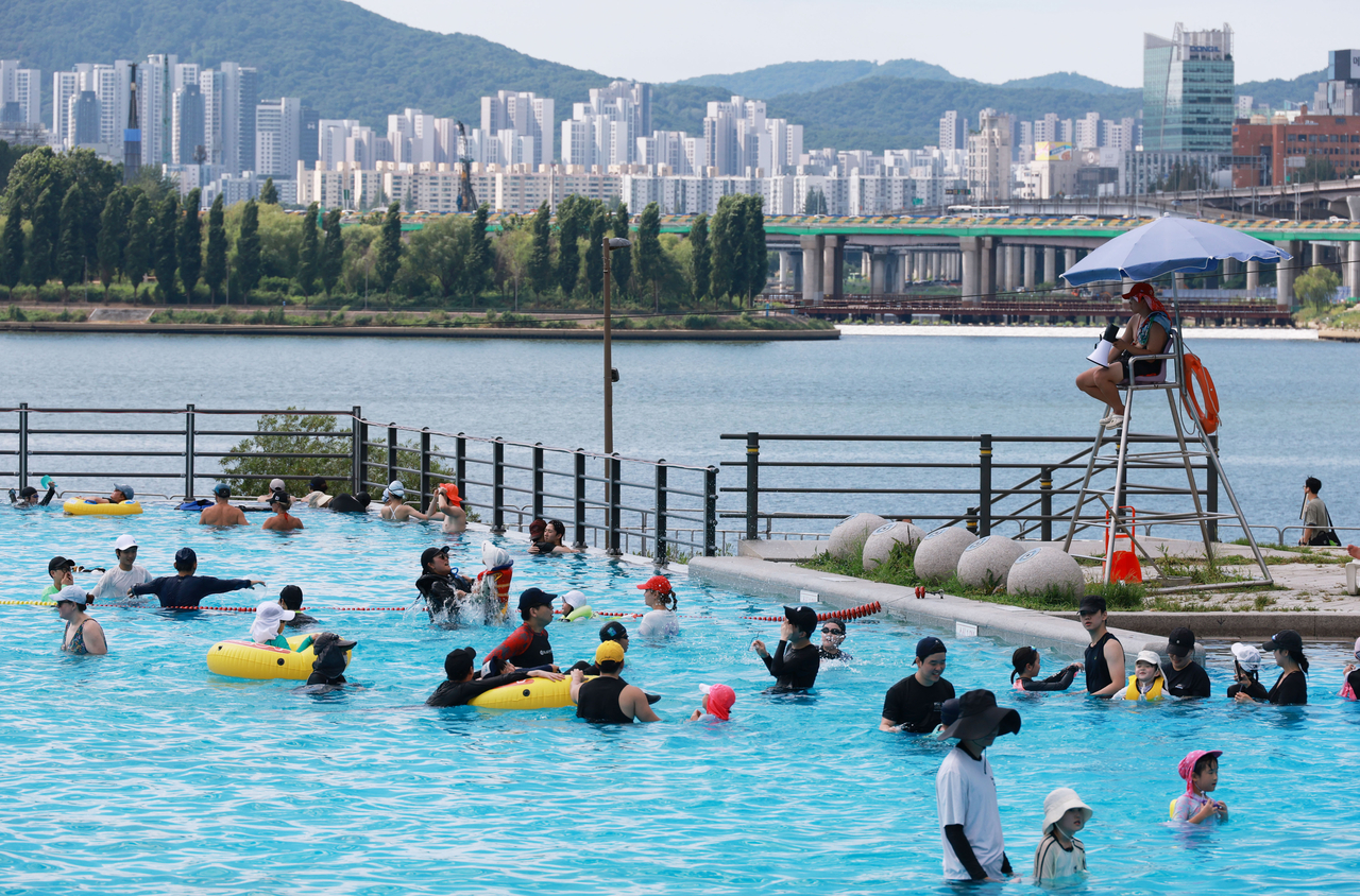 Residents cool off in a pool at Ttukseom Hangang Park in Seoul on Saturday. (Yonhap)