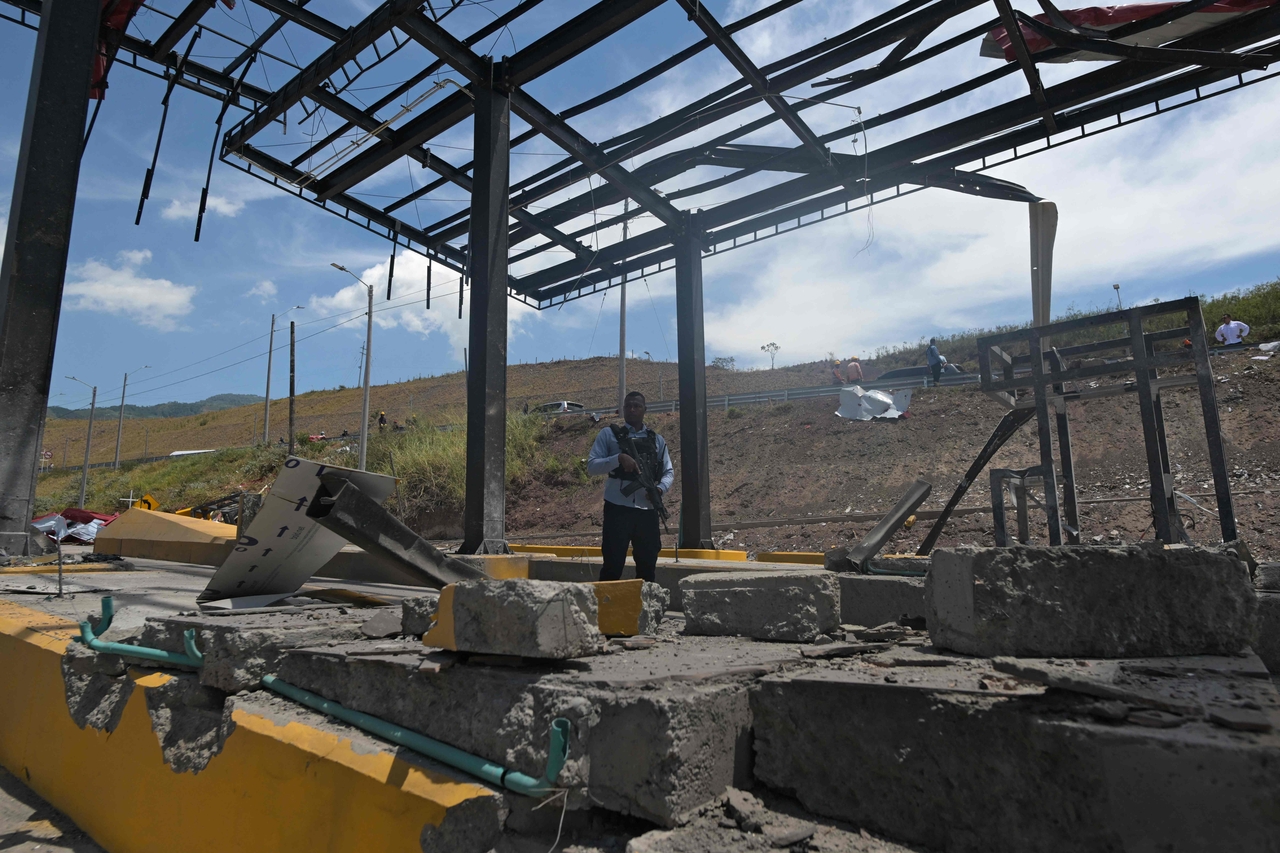 A member of the governor's security detail stands guard after a toll plaza was attacked in Santander de Quilichao, Cauca department, Colombia, Monday. (AFP-Yonhap)