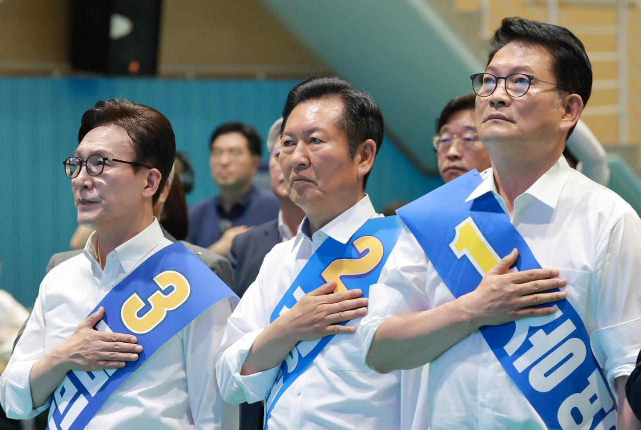From left: Democratic Party leadership candidates Reps. Kim Min-seok, Jung Chung-rae and Song Young-gil honor the national flag during a joint campaign speech event in Gangwon Province on Sunday. (Yonhap)