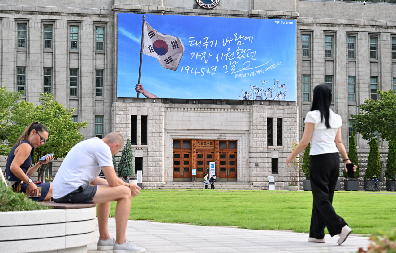 10일 오전 서울 중구 서울도서관 외벽 꿈새김판이 제81주년 광복절 기념 문안으로 단장한 가운데 시민들이 선선한 날씨 속 출근길을 서두르고 있다. 서울시는 광복 81주년을 맞아 독립을 위해 헌신한 순국선열의 희생을 기리고 광복의 의미를 시민들과 함께 되새기기 위해 꿈새김판에 ‘태극기 바람에 가장 시원했던 1945년 그날. 광복의 기쁨, 계속 이어갑니다’라는 문구와 함께 푸른 하늘을 배경으로 힘차게 휘날리는 태극기를 담아 광복의 감동과 희망의 메시지를 표현했다고 밝혔다. 임세준 기자