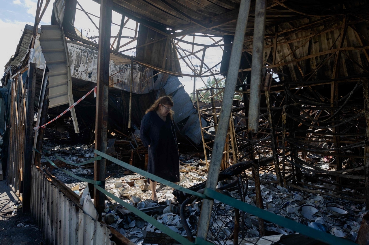 A woman looks at burnt and broken ceramic items at a damaged street market following Russian strikes in Petrivka neighborhood in Kyiv, Ukraine, Sunday. (AFP-Yonhap)