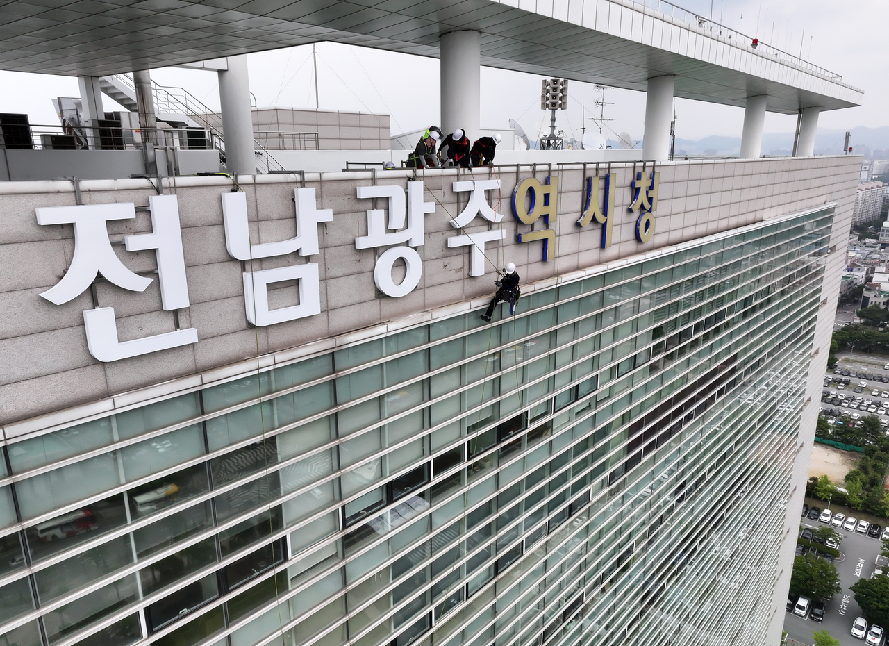 광주광역시청 외벽에서 작업자들이 전남광주통합특별시 간판을 설치하고 있다. <연합뉴스>