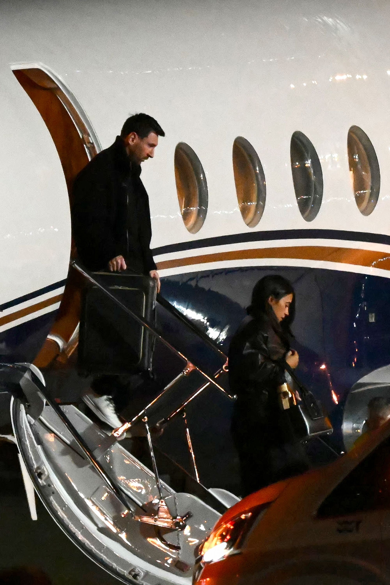 Lionel Messi (left) and his wife Antonela Roccuzzo arrive at the Islas Malvinas International Airport after the death of his father Jorge Messi in Rosario, Argentina on Saturday.    (AFP-Yonhap)