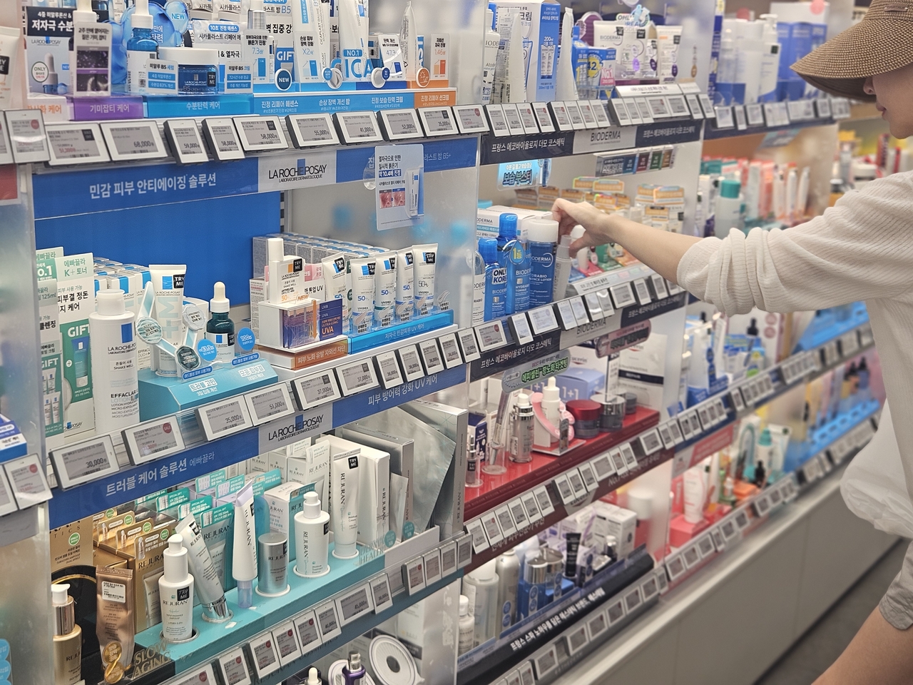 A shopper browses derma cosmetics products at a CJ Olive Young store in Seoul on Monday.