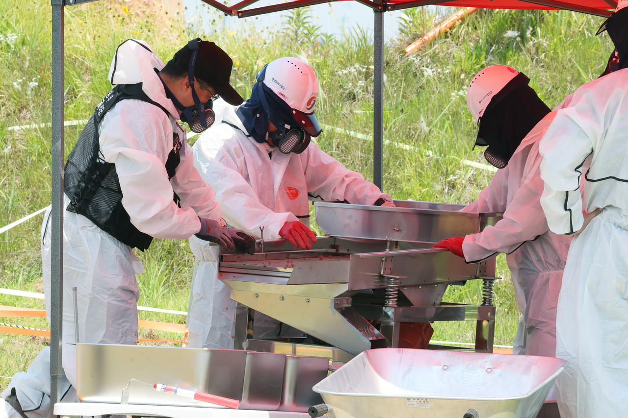This undated file photo shows experts searching for the remains of the 179 people killed in the 2024 Jeju Air plane crash. (Yonhap)