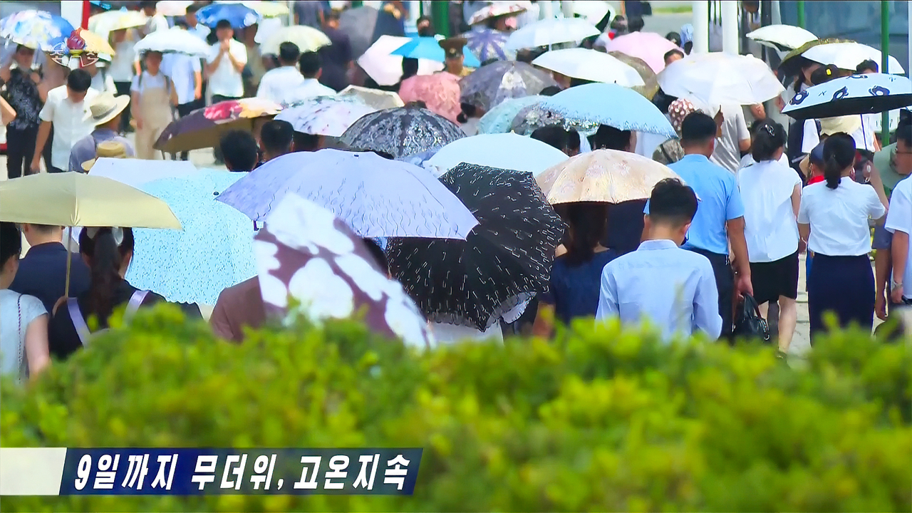 People in Pyongyang, North Korea, walk with parasols on Thursday. (Korean Central Television-Yonhap)