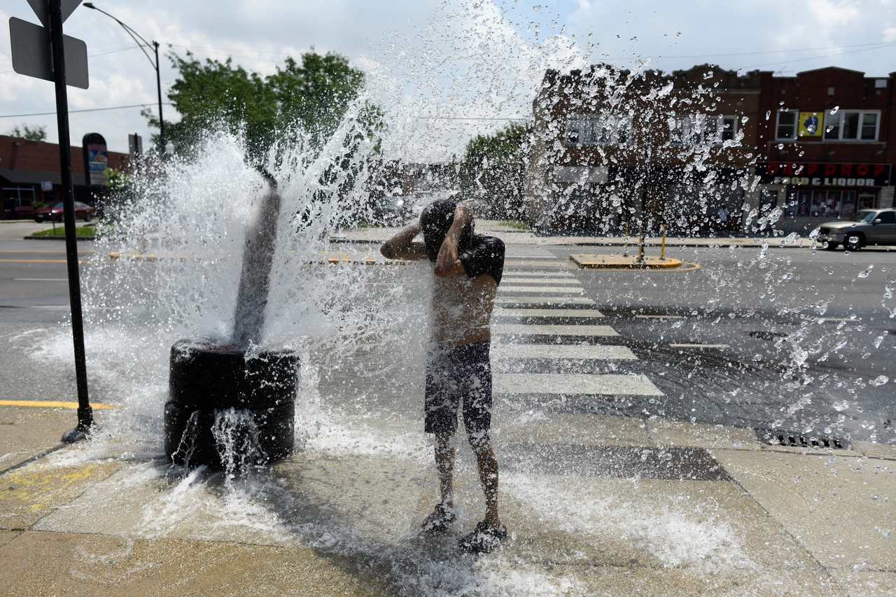 A person cools off with water from an open fire hydrant during a heat wave on the West Side of Chicago, Illinois, July 2. (AFP-Yonhap)