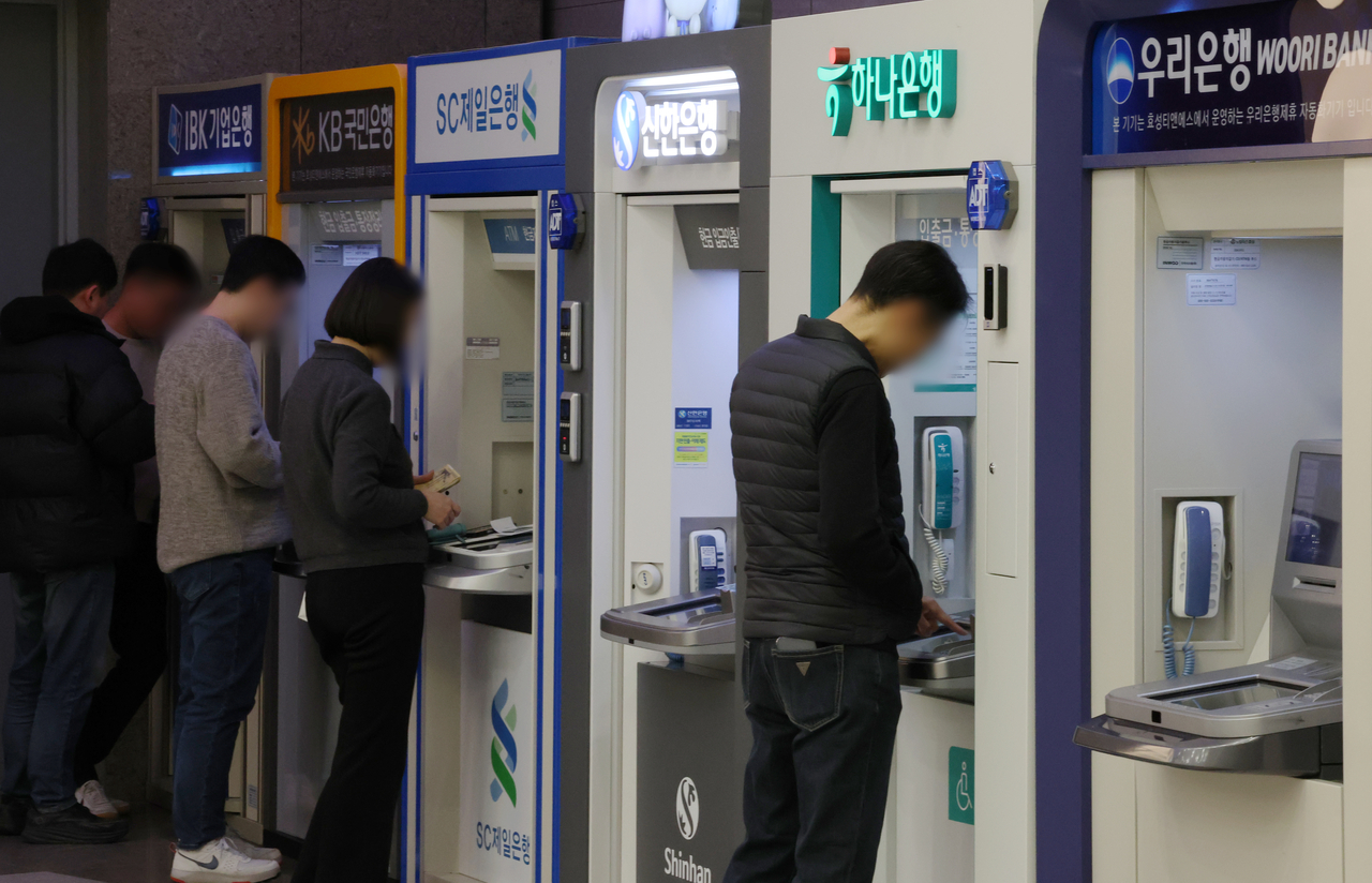 서울 시내의 한 건물에서 시민들이 은행 현금자동입출금기(ATM)를 이용하고 있다. [뉴시스]