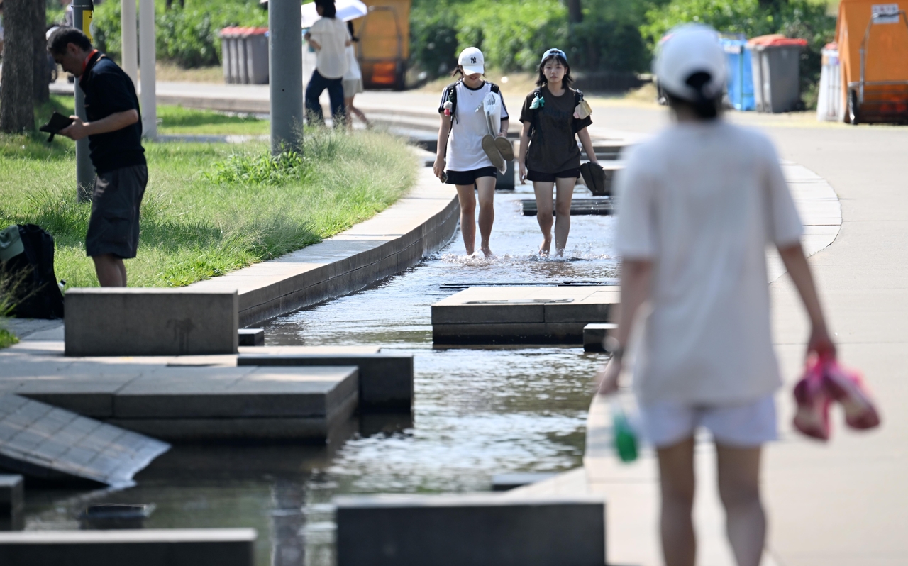 며칠째 전국에 40도가 넘는 극한의 폭염이 계속되는 가운데 지난 3일 오전 서울 여의도 마포대교 남단 아래에서 시민들이 물에 발을 담그며 더위를 식히고 있다 . 이상섭 기자