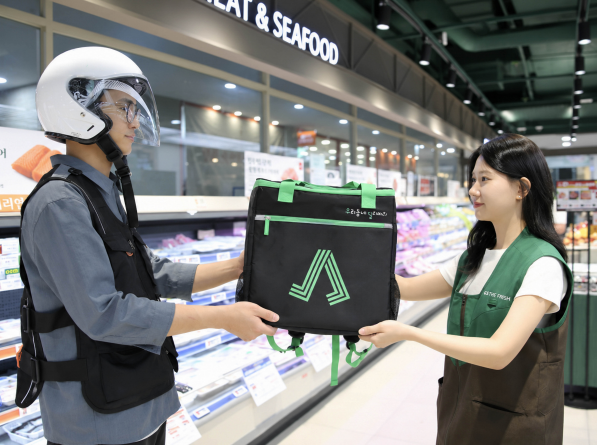 GS더프레시 직원이 퀵커머스 상품을 배송 기사에게 전달하고 있다.  [GS리테일 제공]