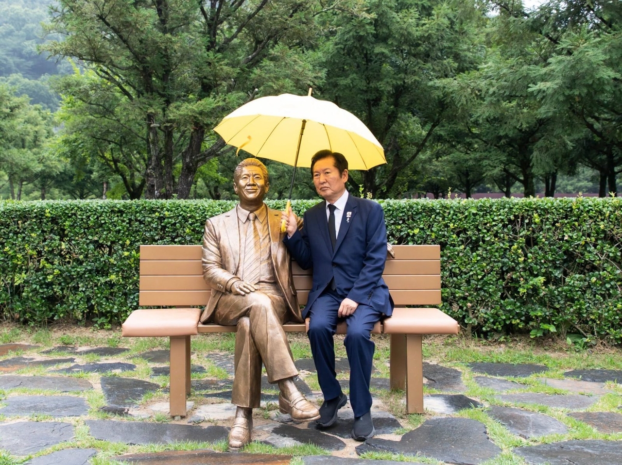 Rep. Jung Chung-rae (right) pose for a photo with a lifesize statue of late former liberal president Roh Moo-hyun near Roh's tomb in Gimhae, South Gyeongsang Province in July. (Jung's Facebook)