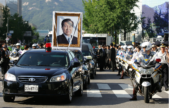 A vehicle carrying a portrait of former South Korean President Kim Dae-Jung moves through crowds of people during his state funeral in Seoul on Aug. 23, 2009. (Getty Images)