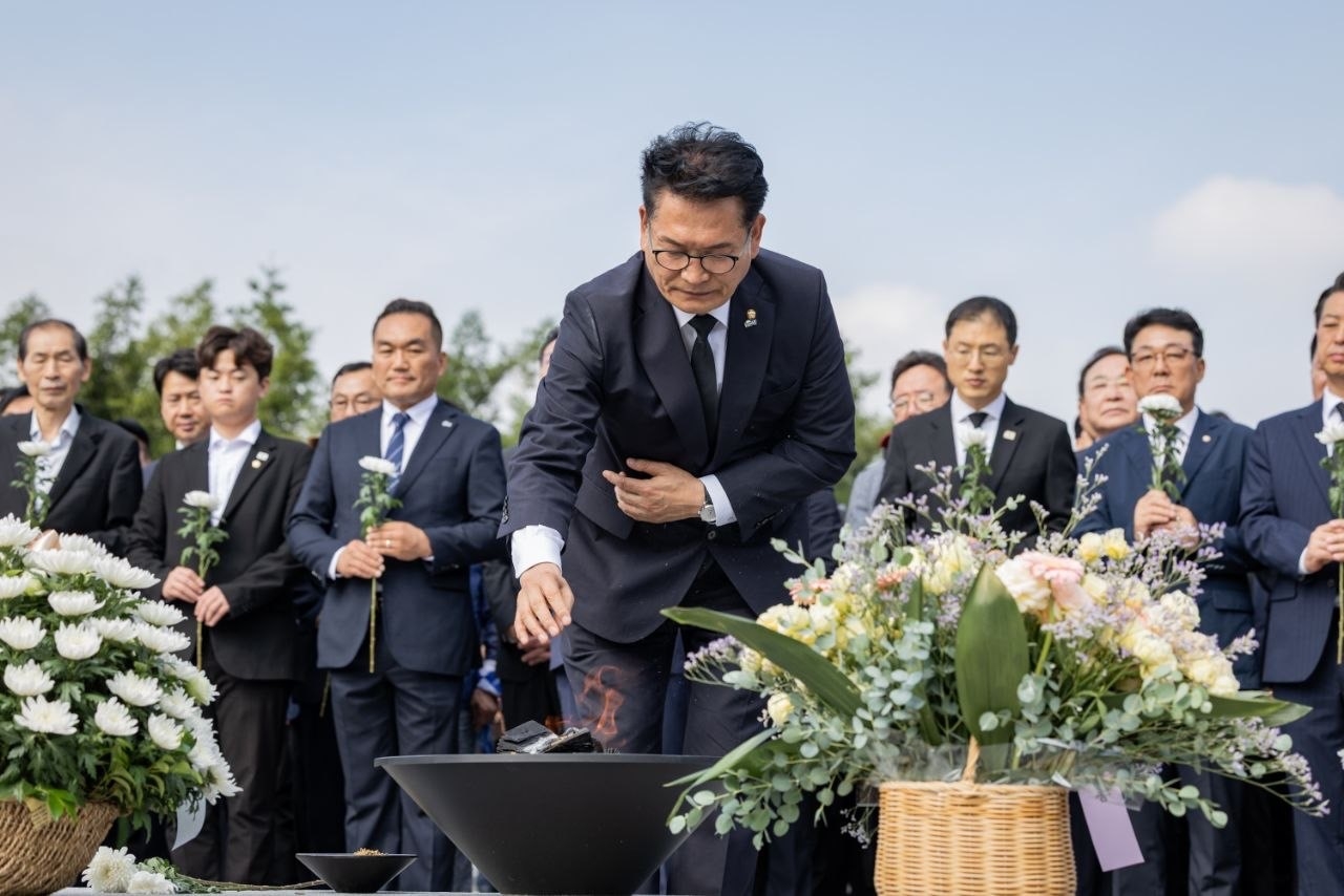Rep. Song Young-gil (center) pays respect to later former president Roh Moo-hyun in his tomb in June. (Newsis)