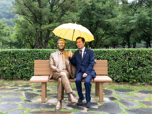 Rep. Jung Chung-rae (right) poses for a photo with a lifesize statue of President Roh Moo-hyun near his tomb in Gimhae, South Gyeongsang Province, in July. (Jung's Facebook)