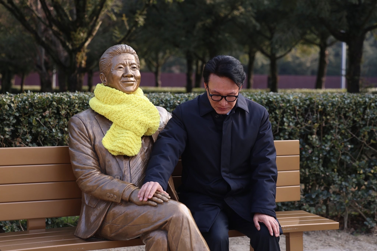 Rep. Kim Min-seok (right) pose for a photo with a lifesize statue of late former liberal president Roh Moo-hyun near Roh's tomb in Gimhae, South Gyeongsang Province in January. (Kim's Facebook)