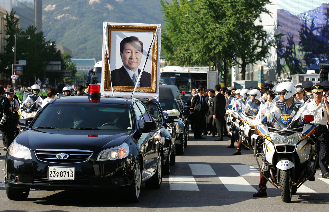 A vehicle carrying a portrait of former South Korean President Kim Dae-Jung moves through crowds of people during the state funeral at the city hall on August 23, 2009 in Seoul, South Korea. (Getty Images)