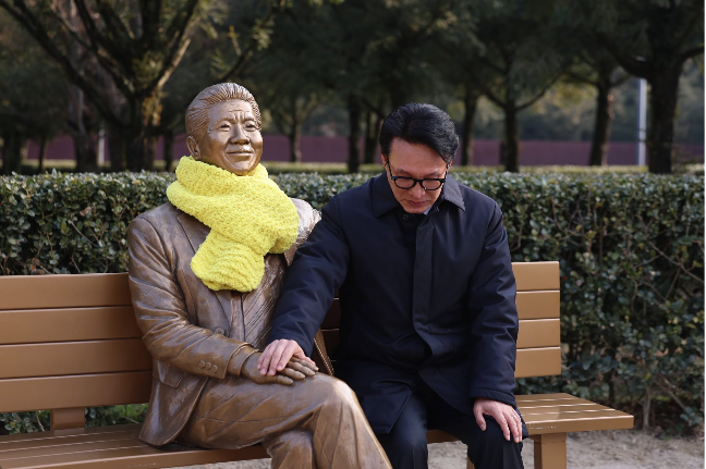 Rep. Kim Min-seok (right) poses for a photo with a lifesize statue of President Roh Moo-hyun near his tomb in Gimhae, South Gyeongsang Province, in January. (Kim's Facebook)