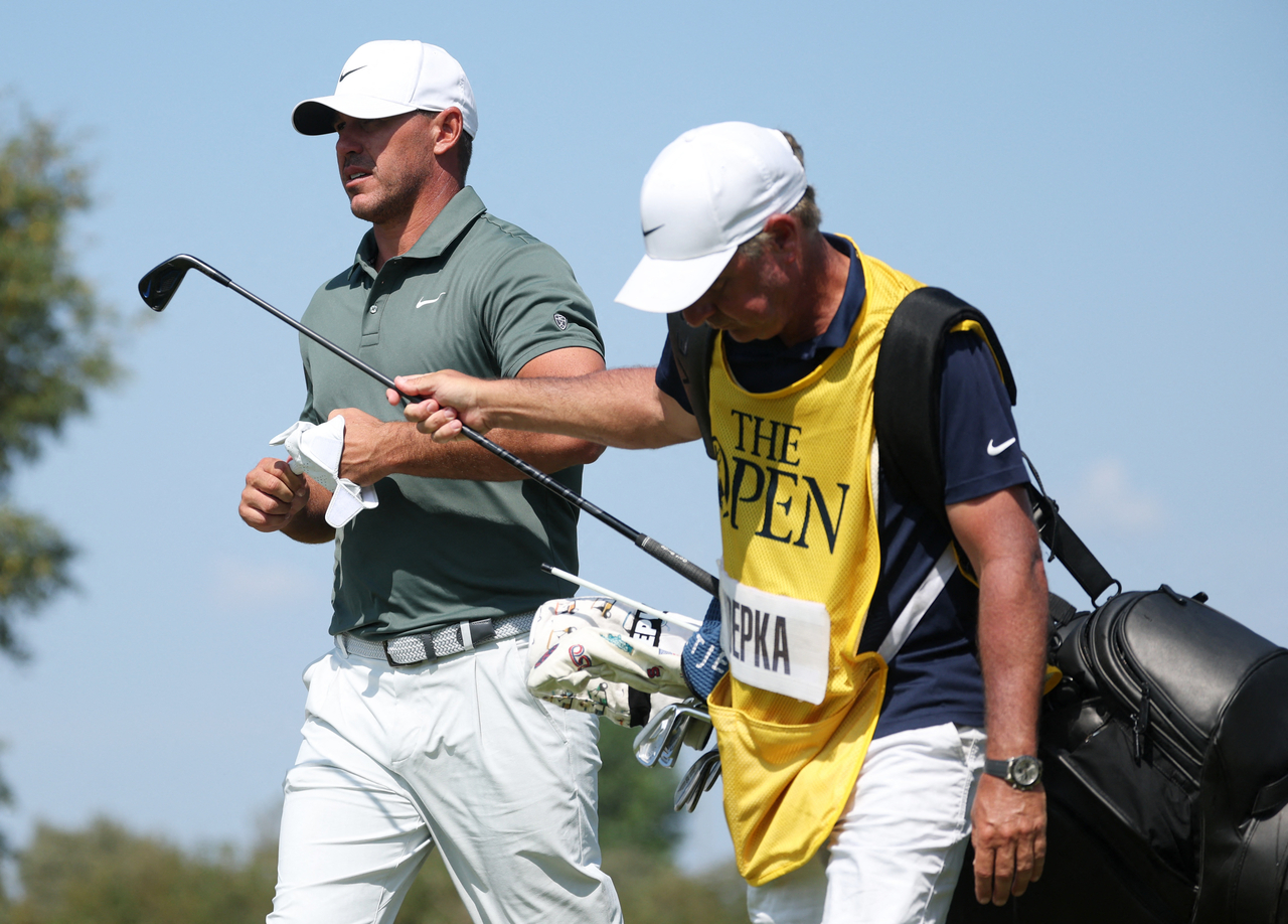 Brooks Koepka (left) walks with his caddie during the first round of The 154th Open Championship, in Southport, England, July 16. Brooks Koepka is one of the most prominent names to defect to PGA Tour from LIV Golf recently.     (Reutets-Yonhap)
