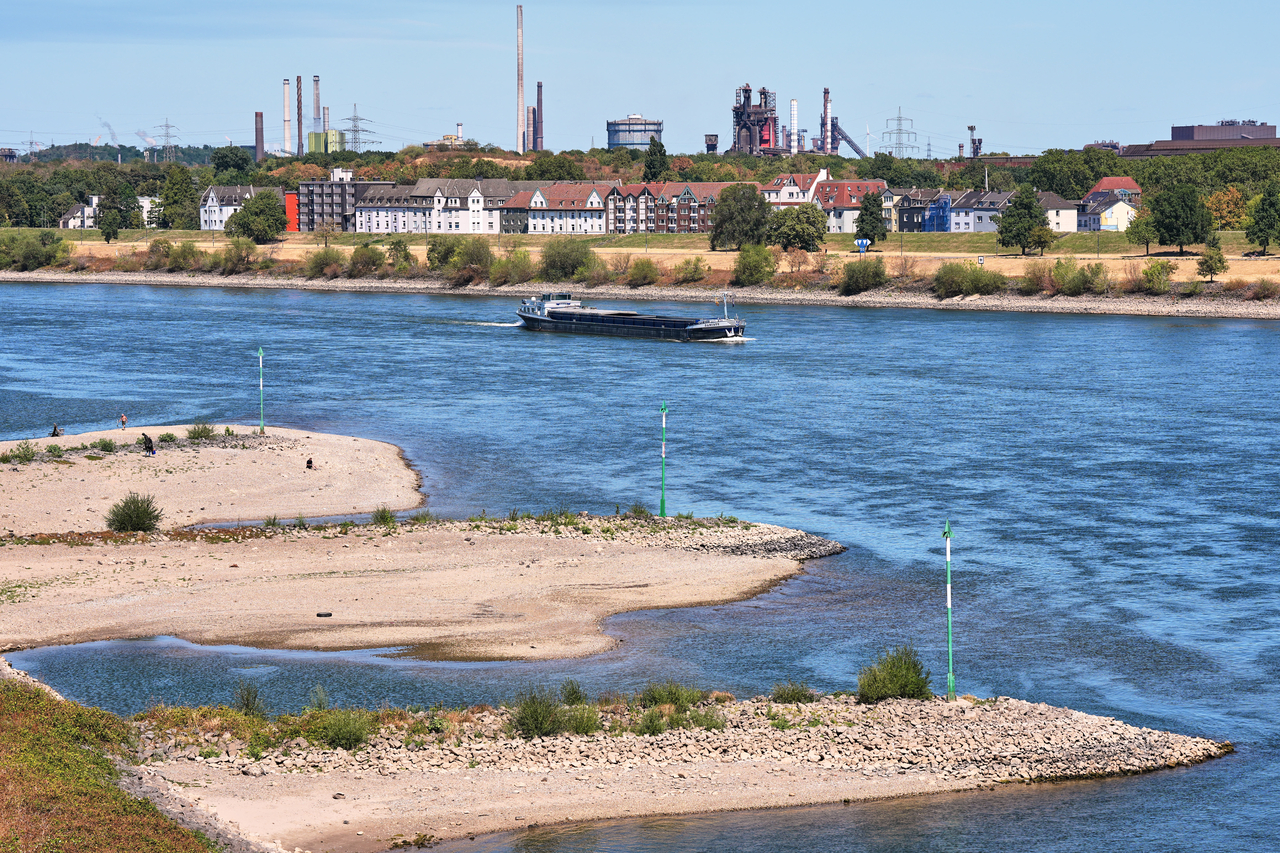 A cargo ship navigates on the Rhine River alongside sandbanks during low water levels caused by a heat wave and a prolonged drought in Duisburg, Germany, Tuesday, Aug. 11, 2026. (AP Photo/Martin Meissner)
