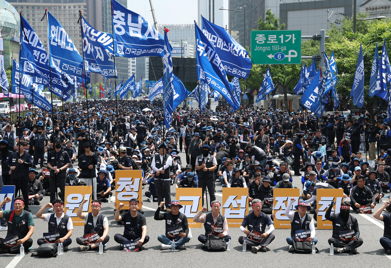 지난 6월 10일 서울 종로구 광화문광장 인근에서 열린 전국금속노동조합(금속노조) 1만 간부 결의대회에서 참가자들이 원청교섭을 요구하는 손팻말과 깃발을 들고 있다. [연합]