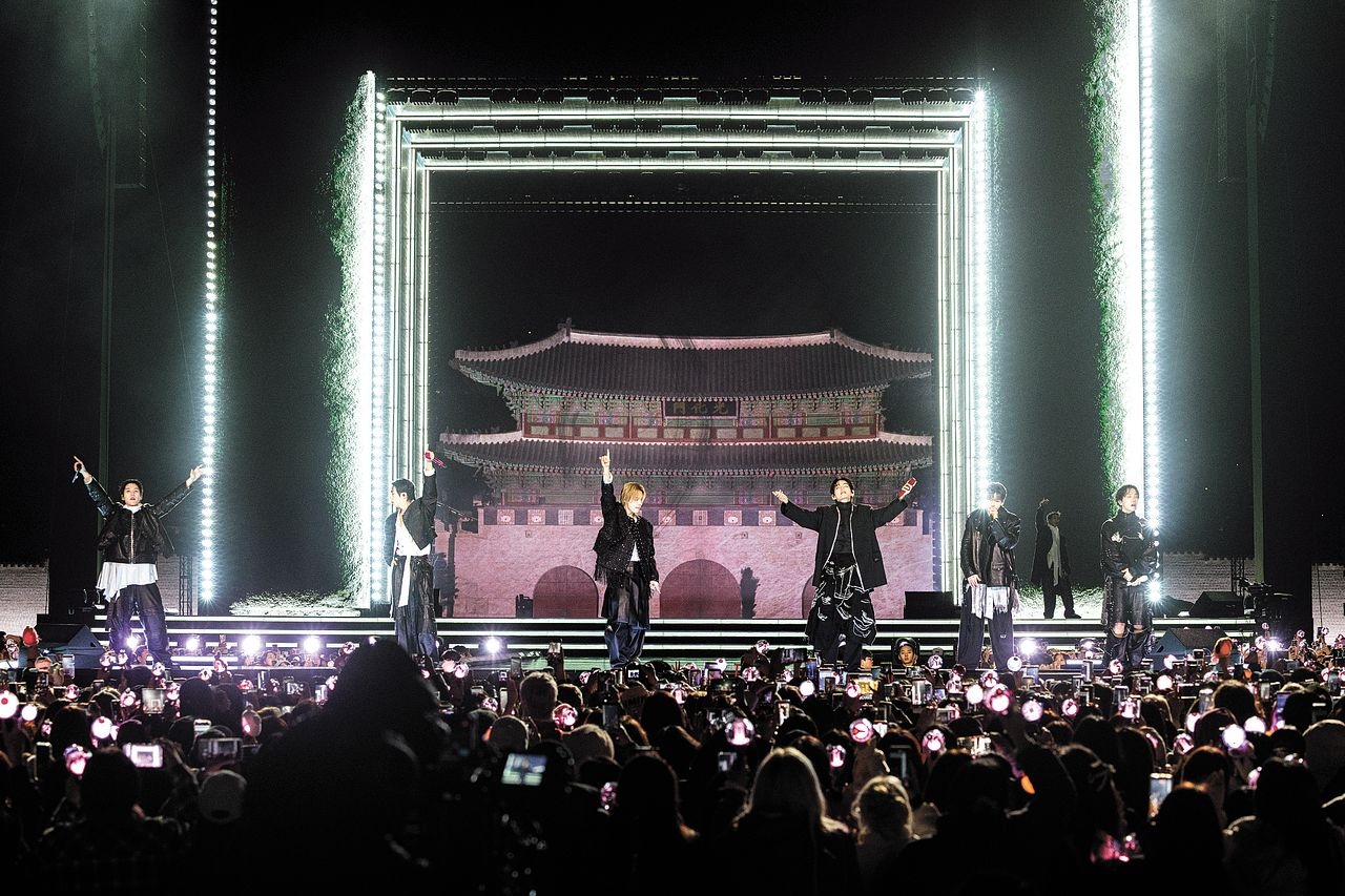BTS members perform live in front of Gwanghwamun palace gate on March 21 for Big Hit Entertainment, wearing coordinated stage looks and demonstrating the stadium-scale performance production that anchored their 2018 Bercy AccorHotels Arena and 2019 La Defense Arena Paris tour dates